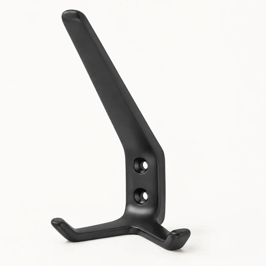 Black STAALFABRIQ coat rack with three hooks mounted on a wall for hanging jackets and accessories.