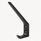 STAALFABRIQ black wall hook with two hooks, mounted on a wall, ideal for hanging coats, bags, or accessories.